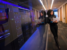 black woman working on computer in the hallway, diversity, SysAdmin Day