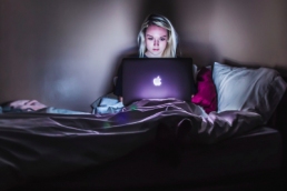 woman working from home in bed, IT professional