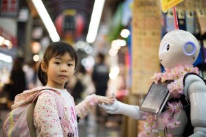 young Japanese girl making friends with robot