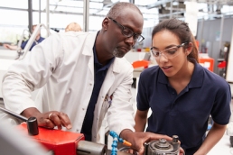 Engineer showing equipment to a female apprentice, close up