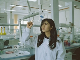 female scientist looking at microscope slide, women in STEM