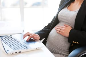 pregnant woman working at a laptop, pregnancy