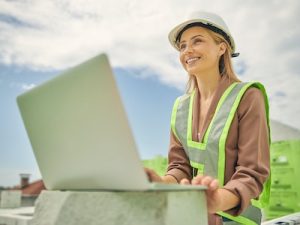 Low angle of blonde woman with happy smile looking into the distance, geospatial industry, women in stem