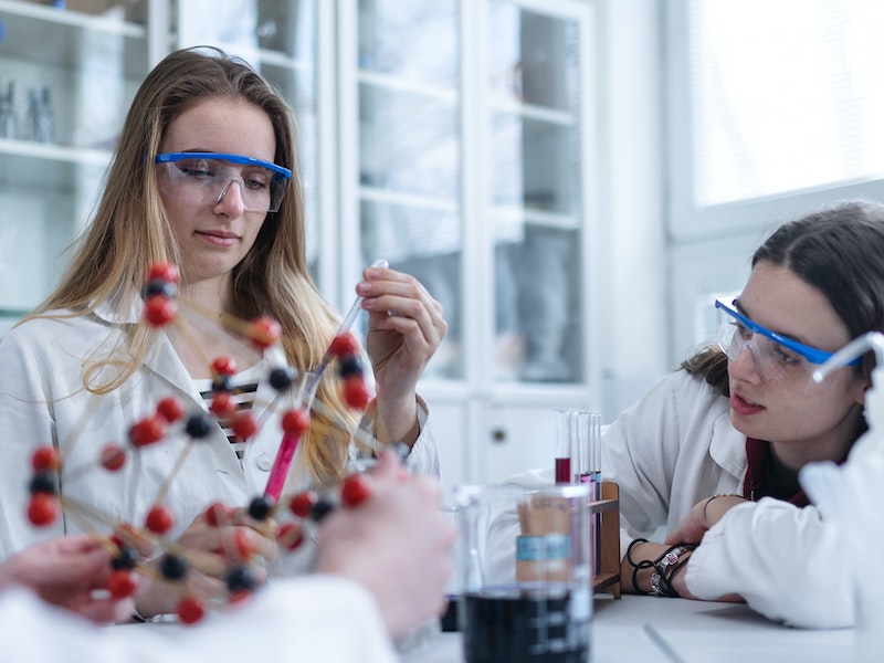 Women in science, students doing chemical experiment in lab