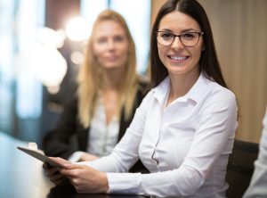 Businesswoman in office holding tablet smiling