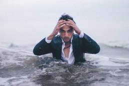 Man in the sea representing drowning in work/stress