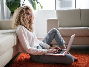 woman on her laptop sitting on the floor of a lovely sitting room